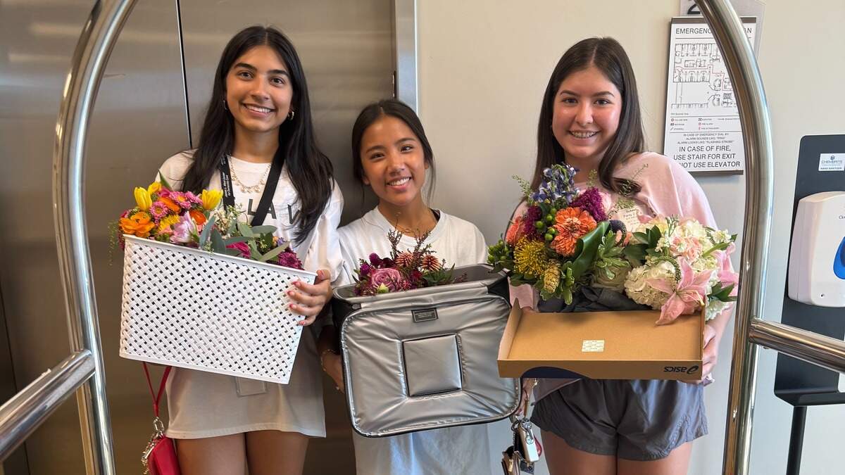 Thrisha Sukesh, Kaylee Crain, and Miya Fisher deliver flower arrangements to James L. West Center for Dementia Care.